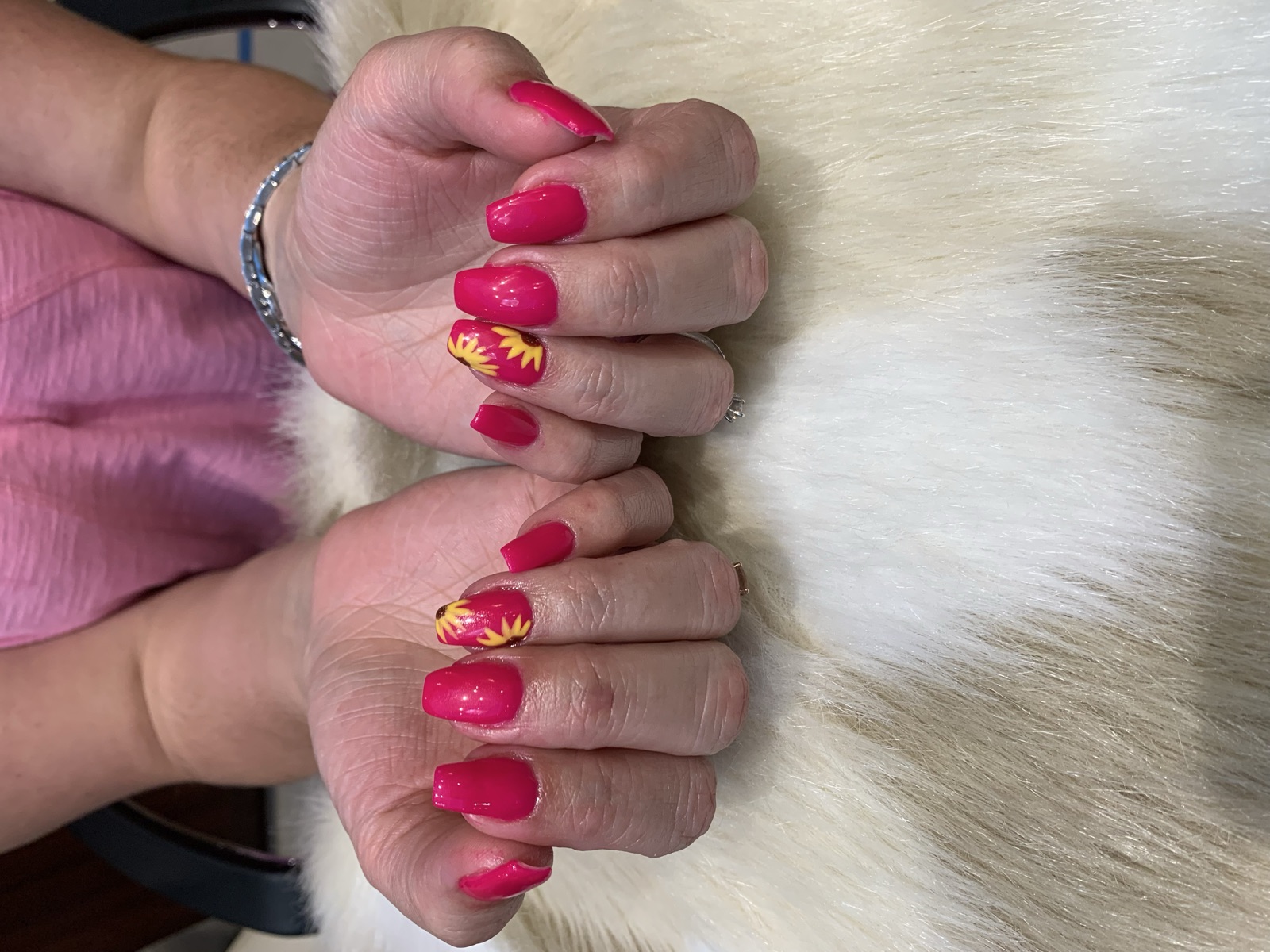 Square magenta nails with sunflower art on the ring fingers