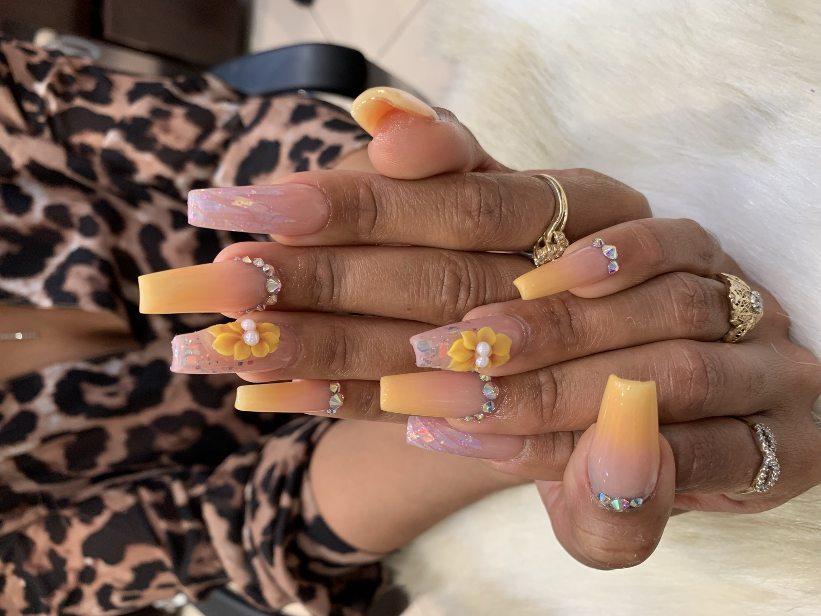 Peach and pink coffin nails with glitter, rhinestones, and 3D yellow flowers
