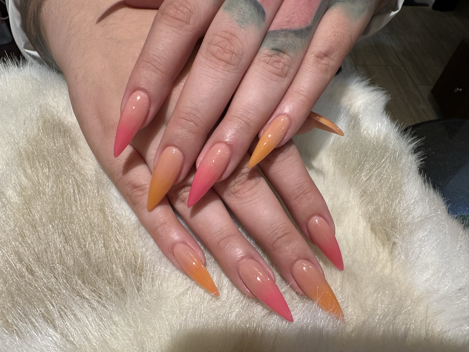 Stiletto nails with a nude-to-hot-pink and orange ombré gradient