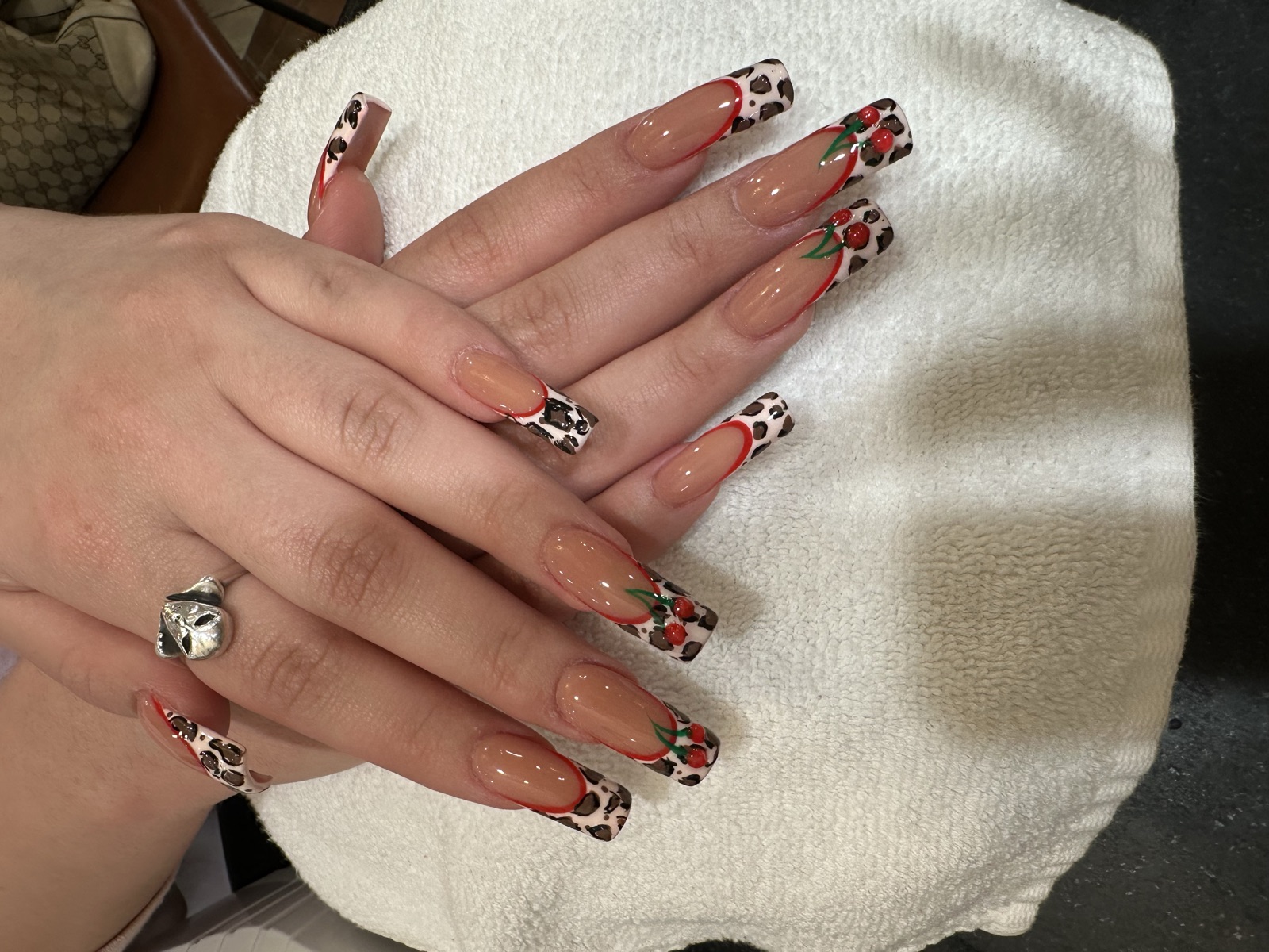 Square nails with leopard-print tips, red lines, and cherry nail art