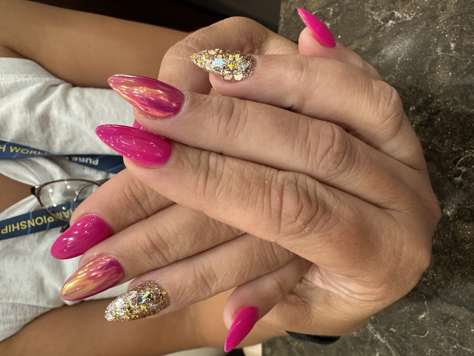Almond nails in fuchsia, iridescent pink chrome, and gold glitter