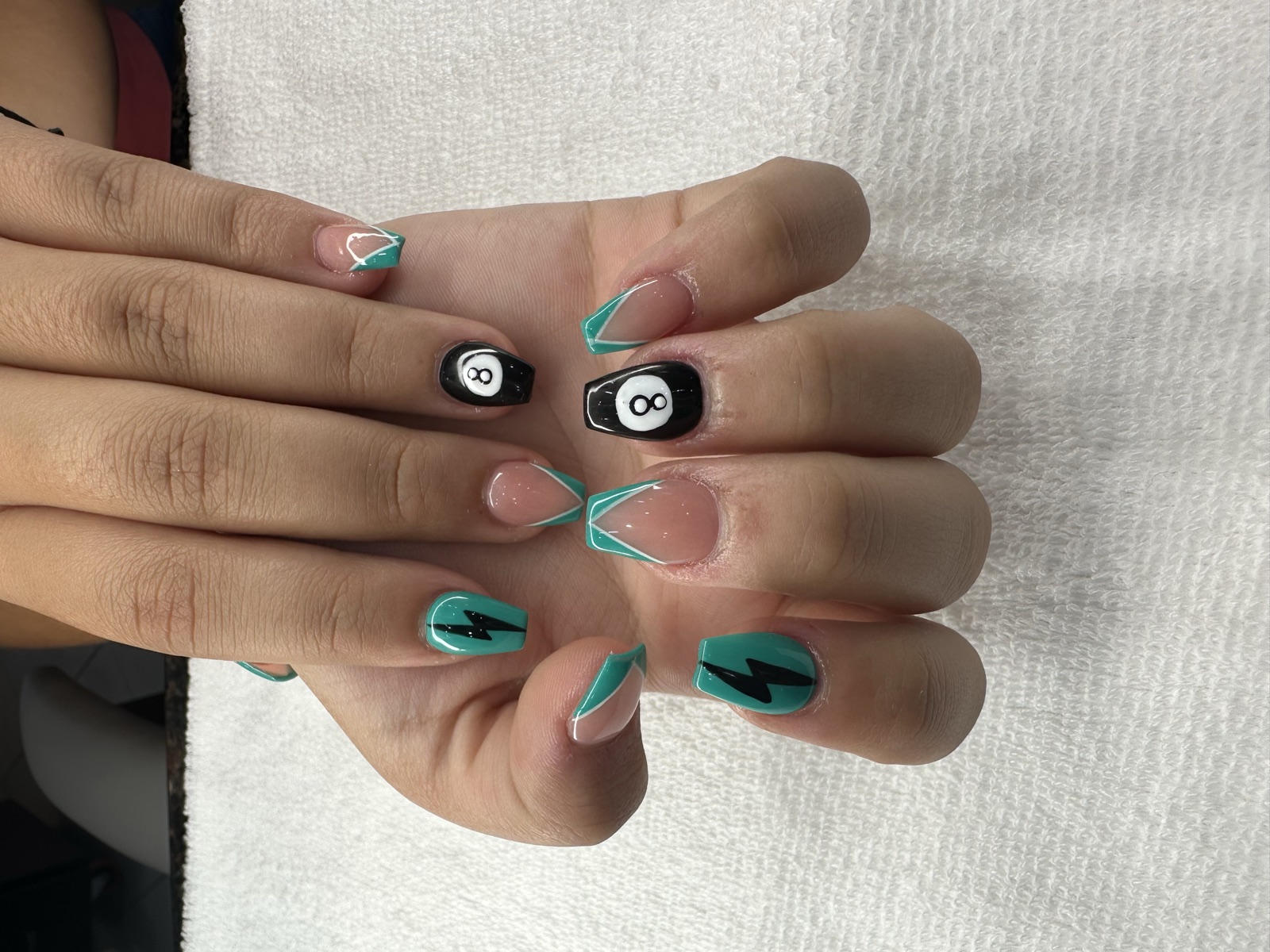 Coffin nails with teal French tips, lightning bolts, and 8-ball nail art