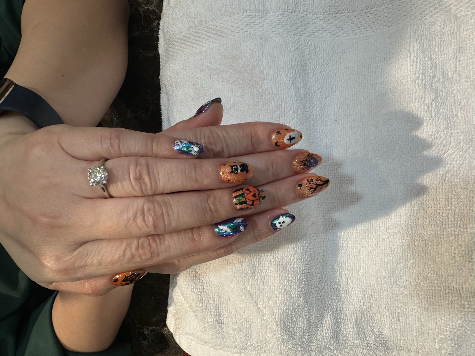 Halloween nail art with pumpkins, ghosts, black cats, and spiders